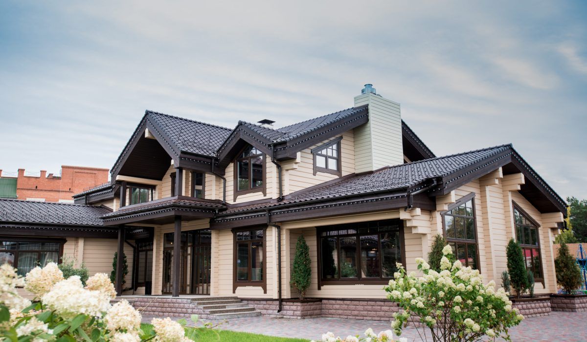 A large house with a lot of windows and flowers in front of it.