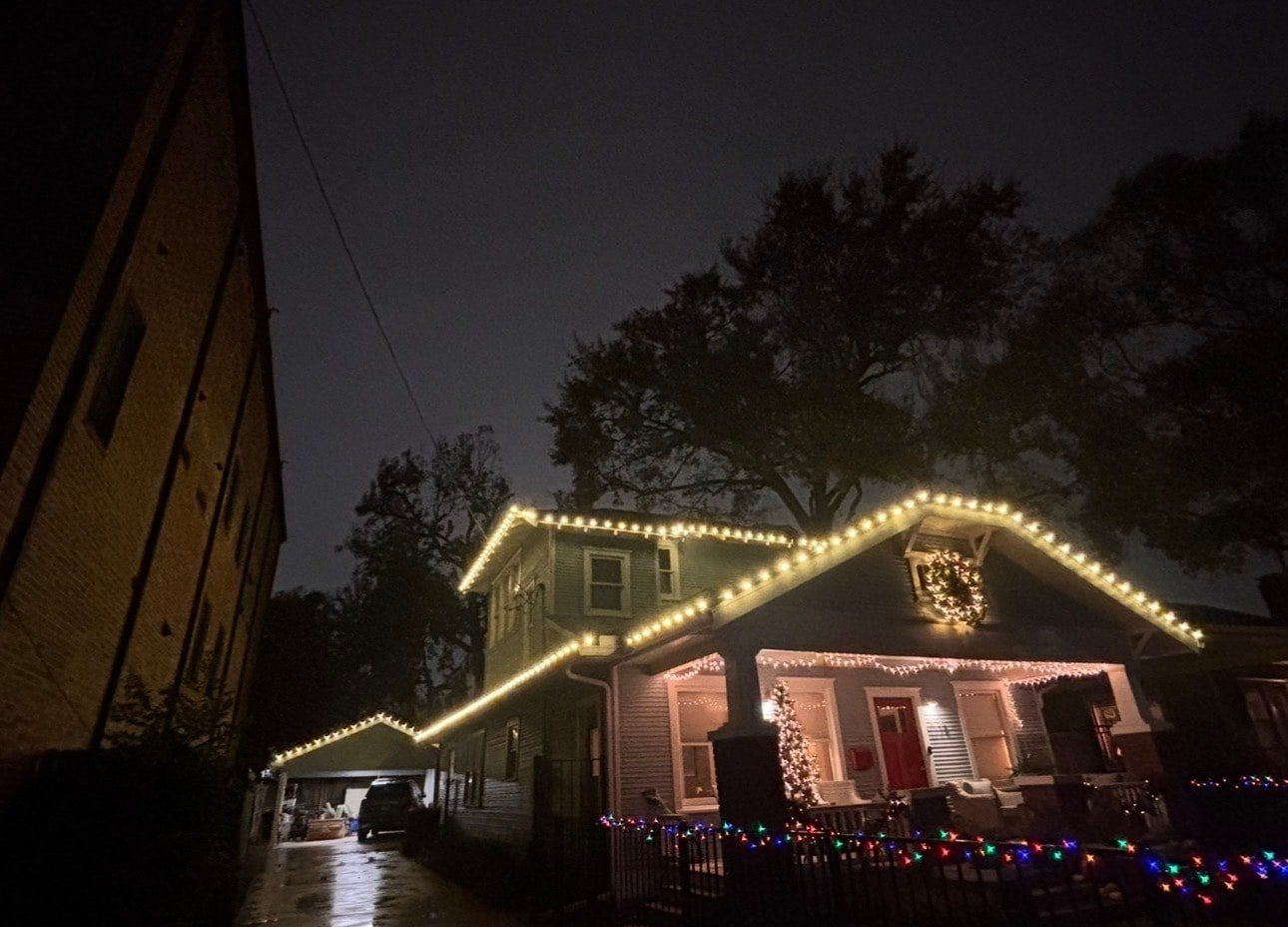 Multicolor C9 bulbs along a roofline with a lit porch below