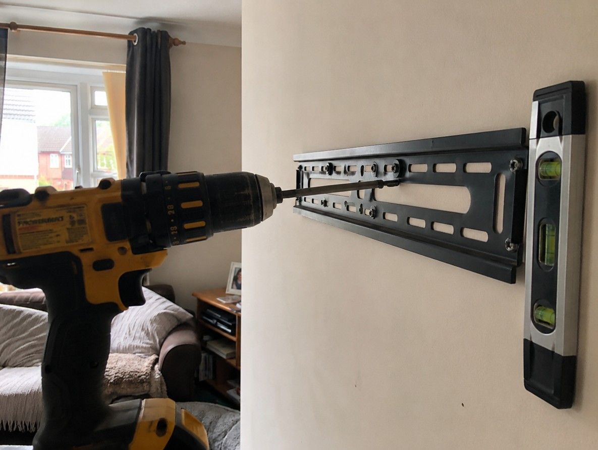J&Z Property Maintenance handyman mounting a TV on a wall in a Cardiff home