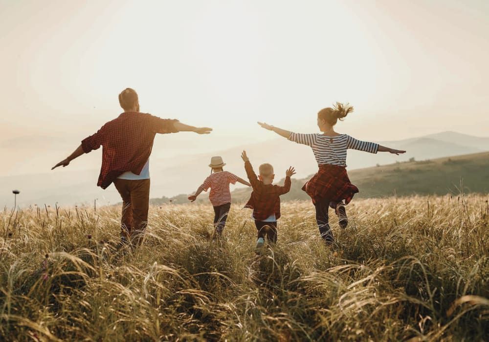 Happy family running on grass field