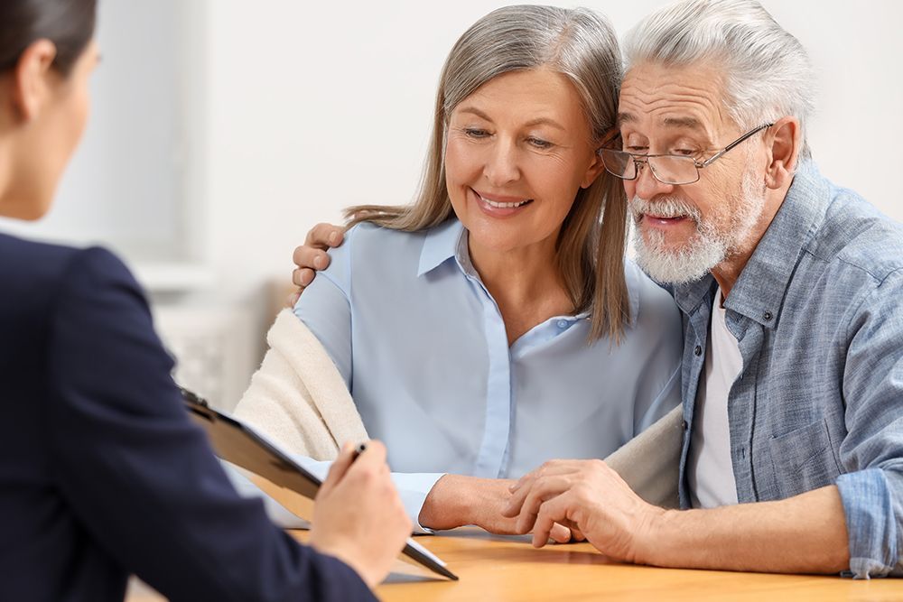 A financial advisor shows paperwork to an older couple. 