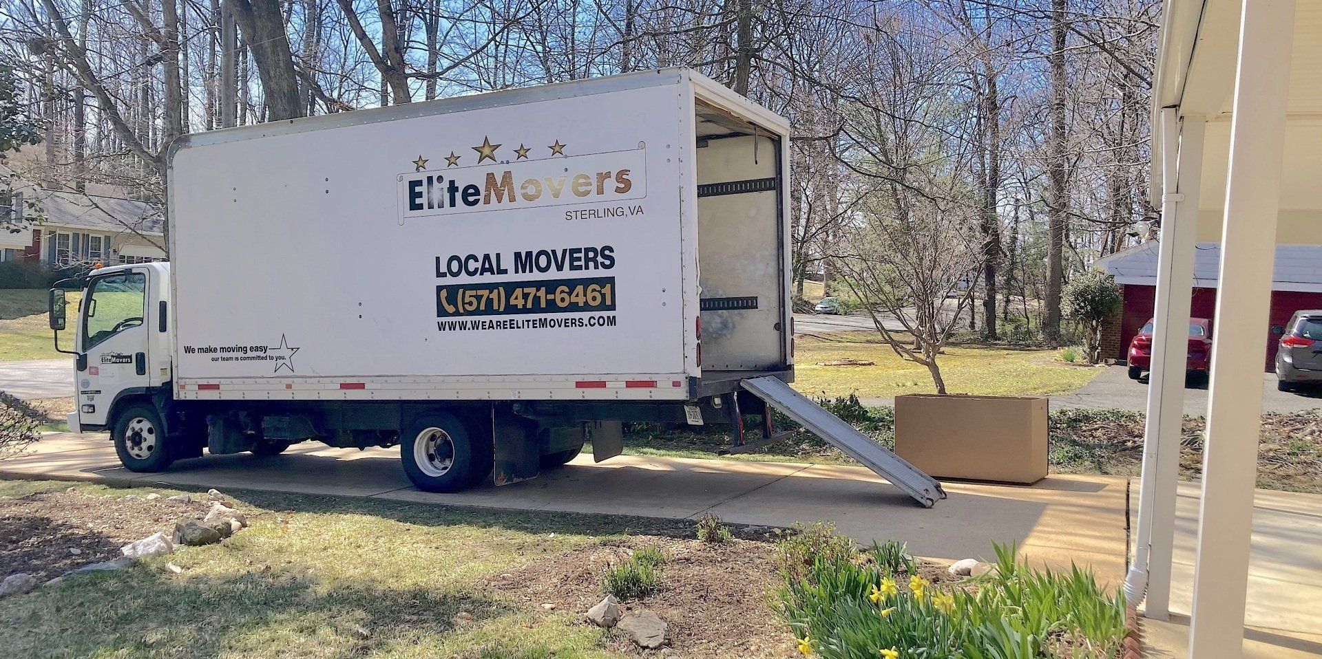 elite movers a moving truck is parked in the driveway