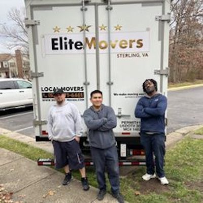 3 employee are standing behind a white truck