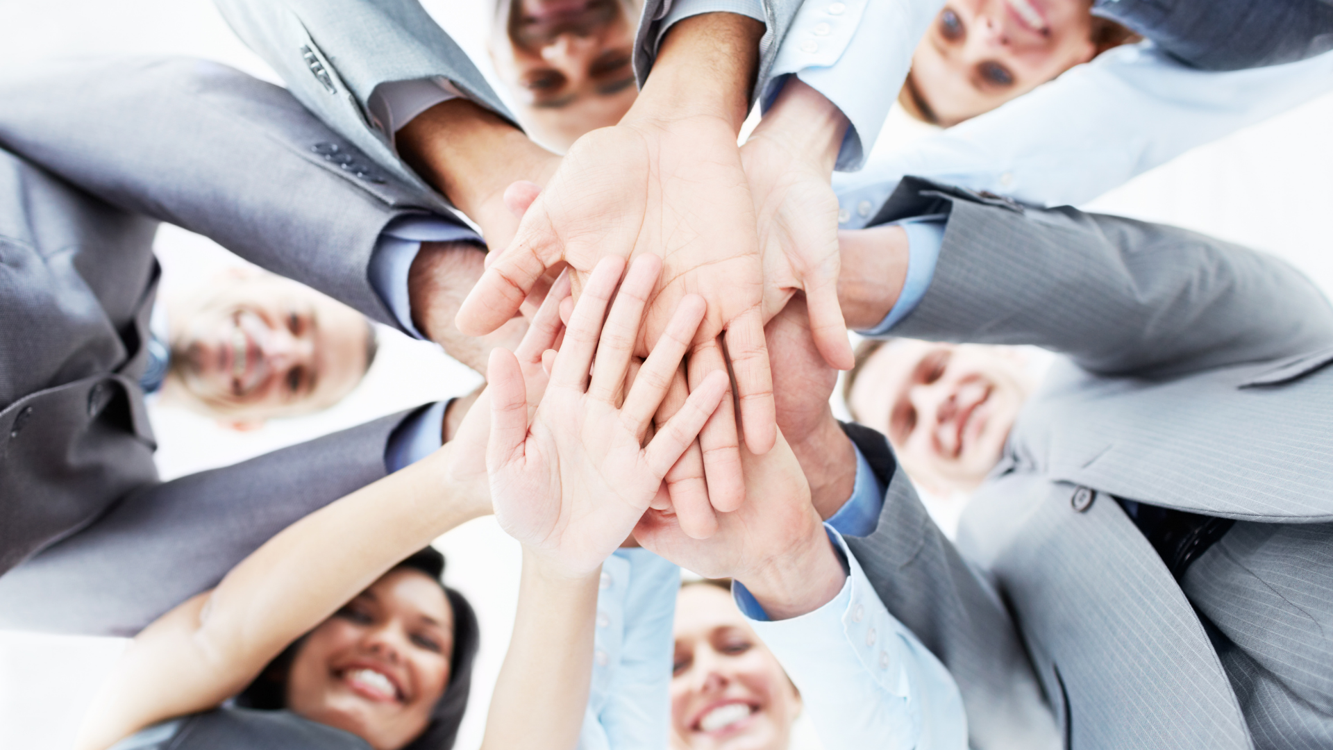 Team stacked hands in a circle, showing unity and collaboration