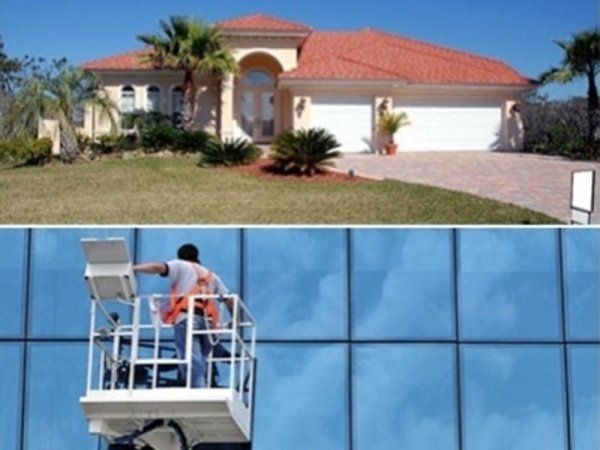 Una casa residenziale con il tetto rosso e, al piano inferiore, una persona in ascensore che pulisce le grandi finestre di un ufficio.