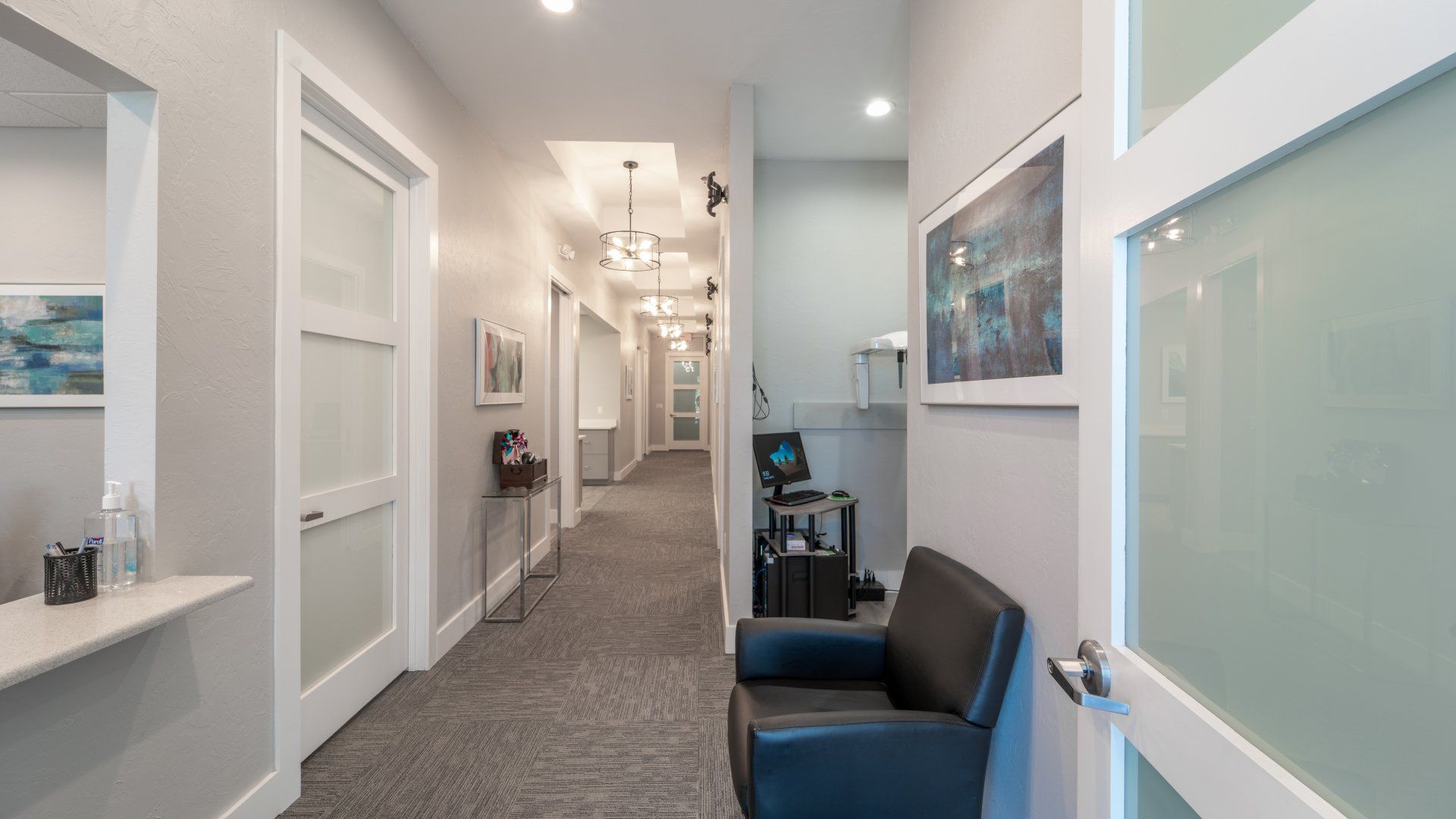 A long hallway with a chair in the middle of it.