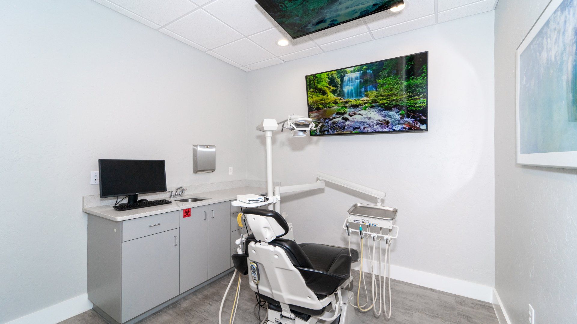 A dental office with a dental chair and a computer.
