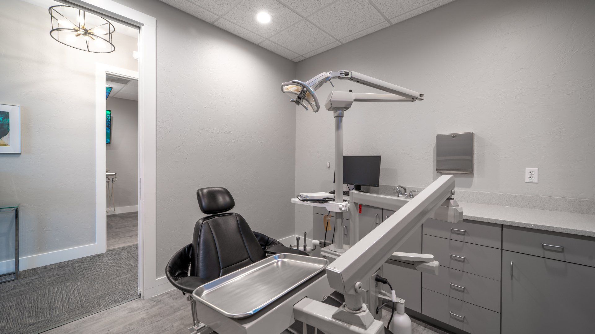 A dental office with a dental chair and a computer.