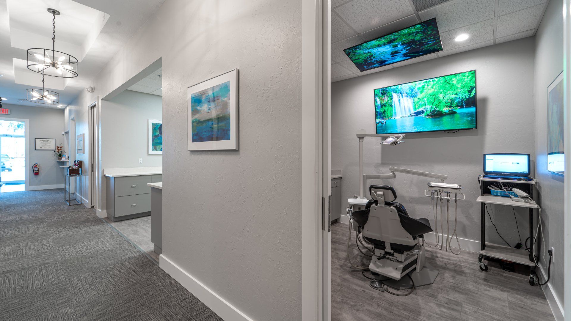 A dental office with a dental chair and a television on the wall.
