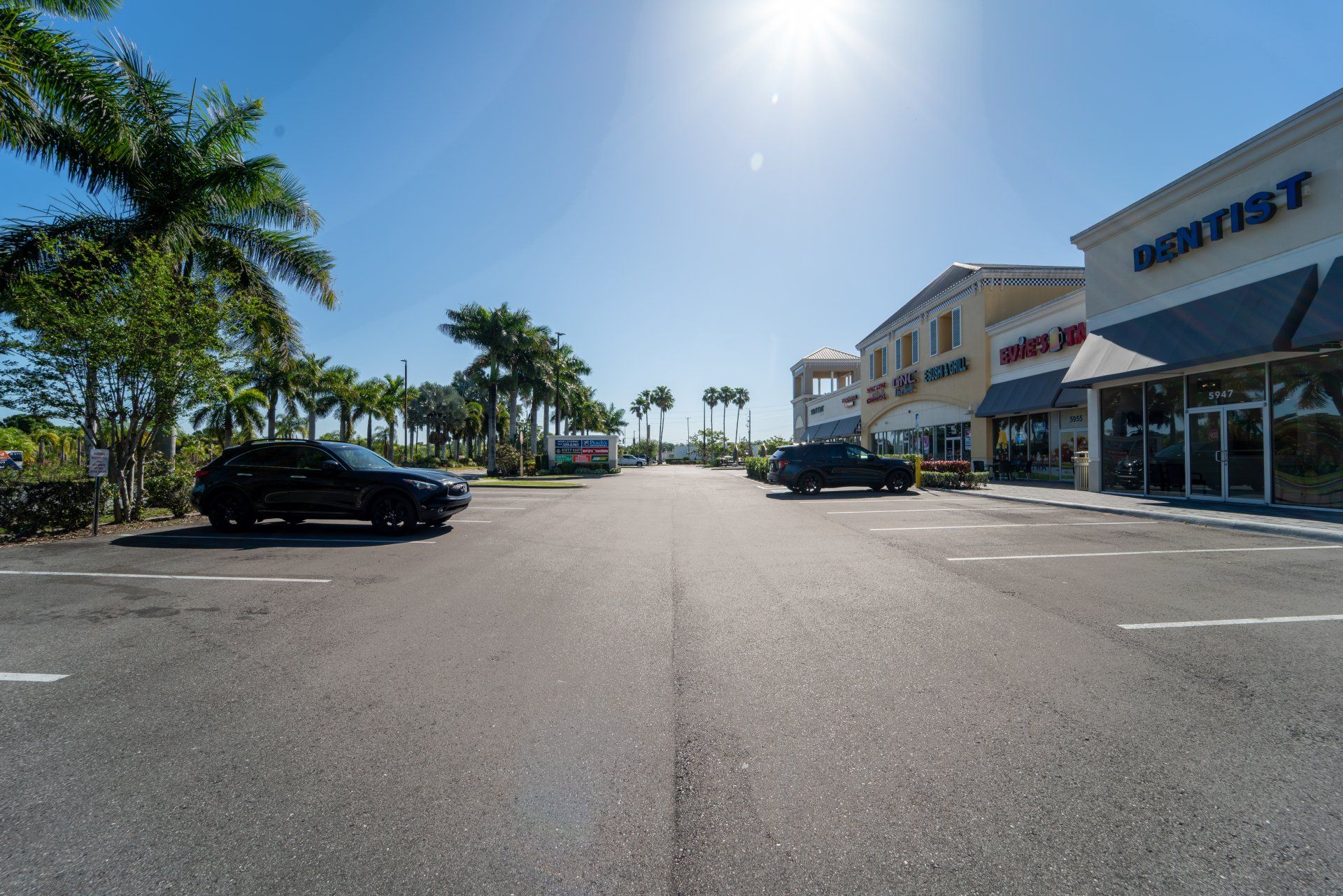 A car is parked in a parking lot in front of a store.