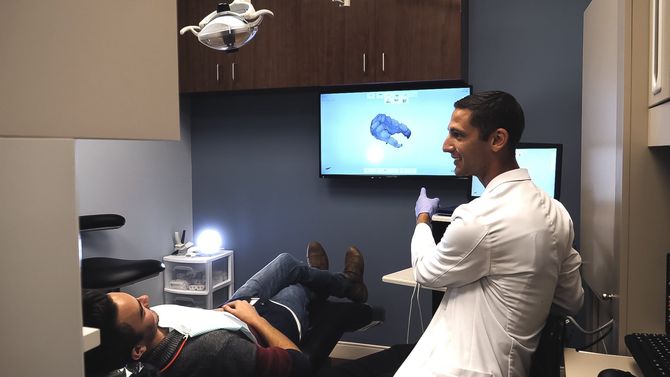 A dentist is examining a patient 's teeth in a dental office.