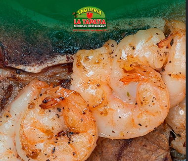 Close-up of grilled shrimp tacos with melted cheese and a green taco logo above