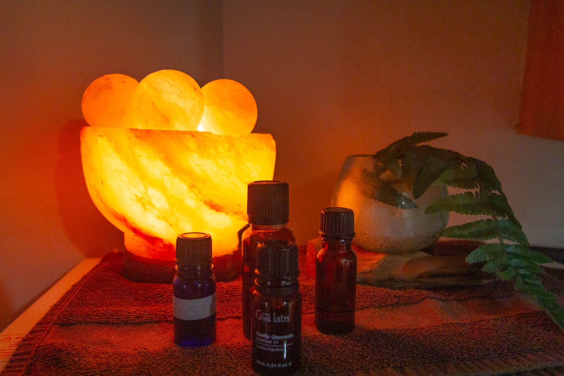 three bottles of essential oils are sitting on a table next to a lamp .