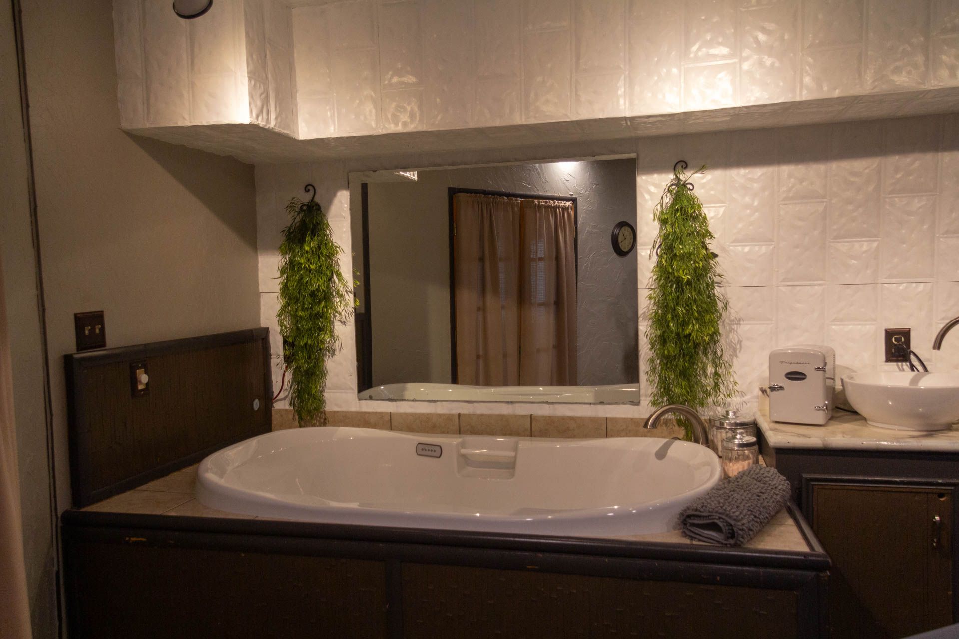 a bathroom with a jacuzzi tub , sink and mirror .