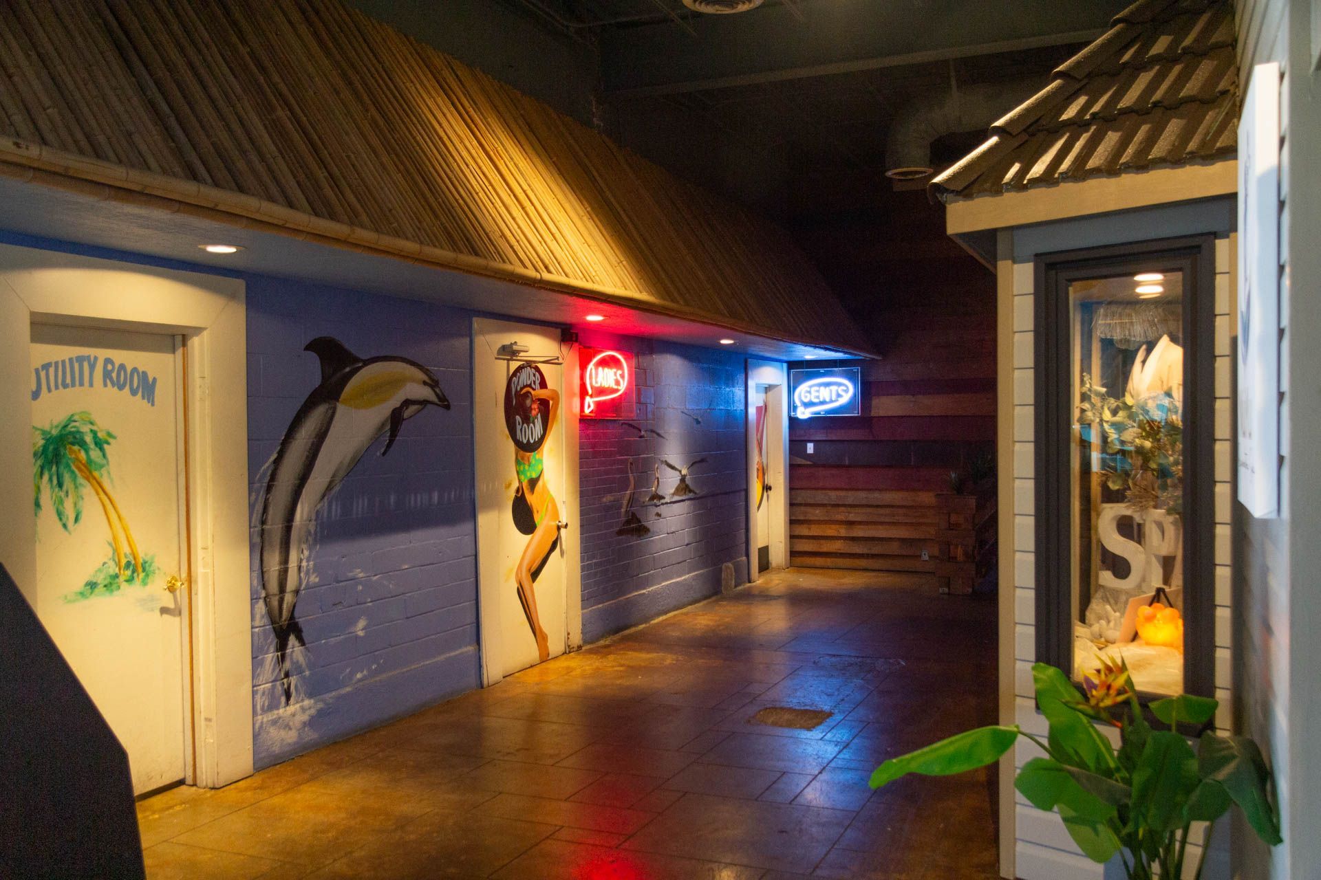a hallway with a dolphin painting on the wall and a palm tree .