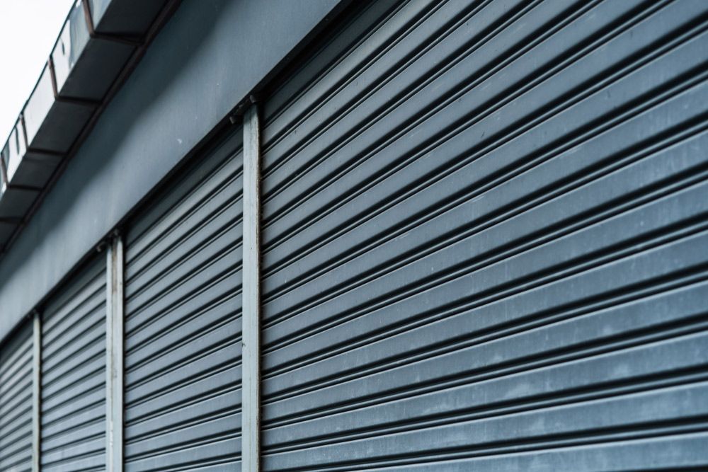 A Close Up Of A Metal Garage Door On A Building In Row — Lighthouse Beach Garage Door Service in Port Macquarie, NSW