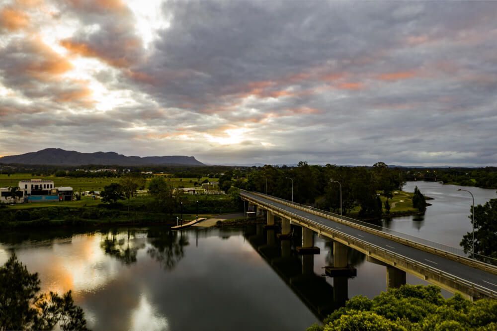 An Aerial View Of A Bridge Over A River At Sunset — Lighthouse Beach Garage Door Service in Wauchope, NSW