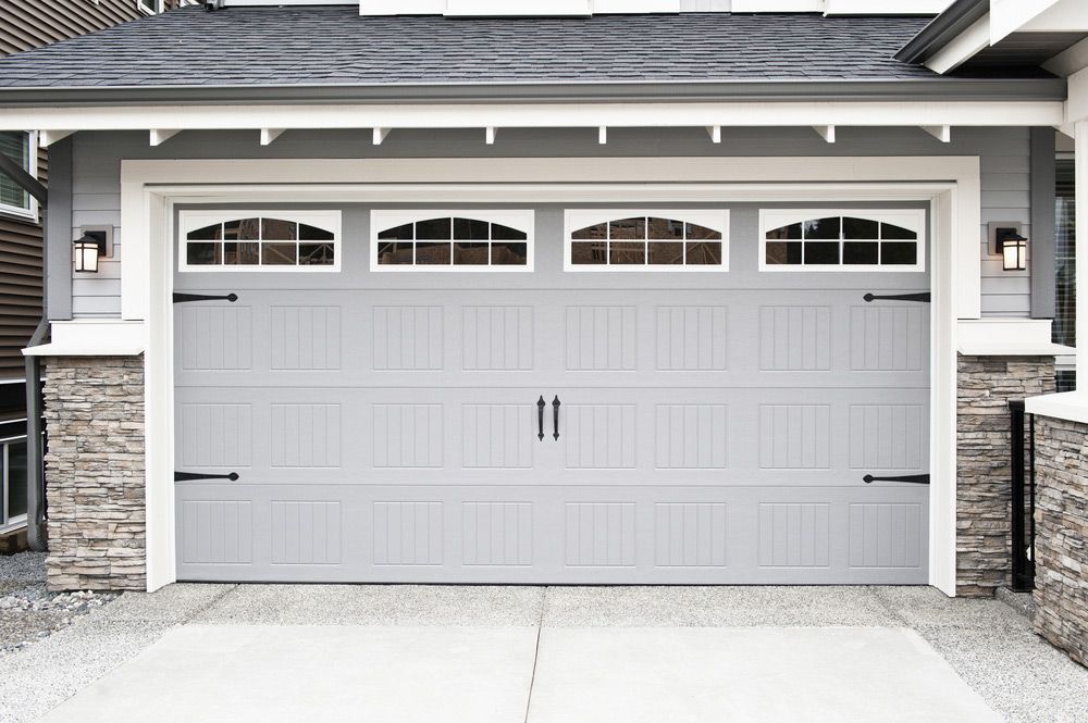 A Gray Garage Door Is Installed In Front Of A House — Lighthouse Beach Garage Door Service in Laurieton, NSW