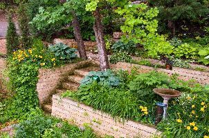 There is a bird bath in the middle of the garden.