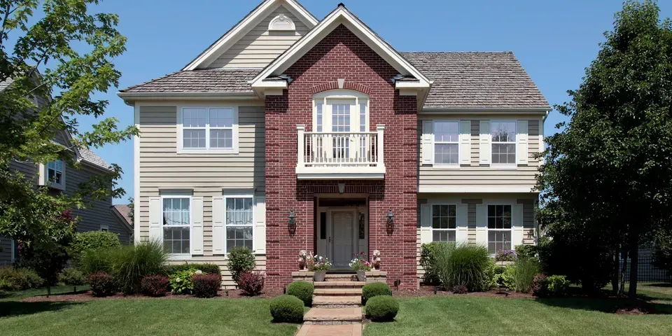 A large house with a brick facade and white siding