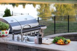 There is a grill and a sink in the backyard.
