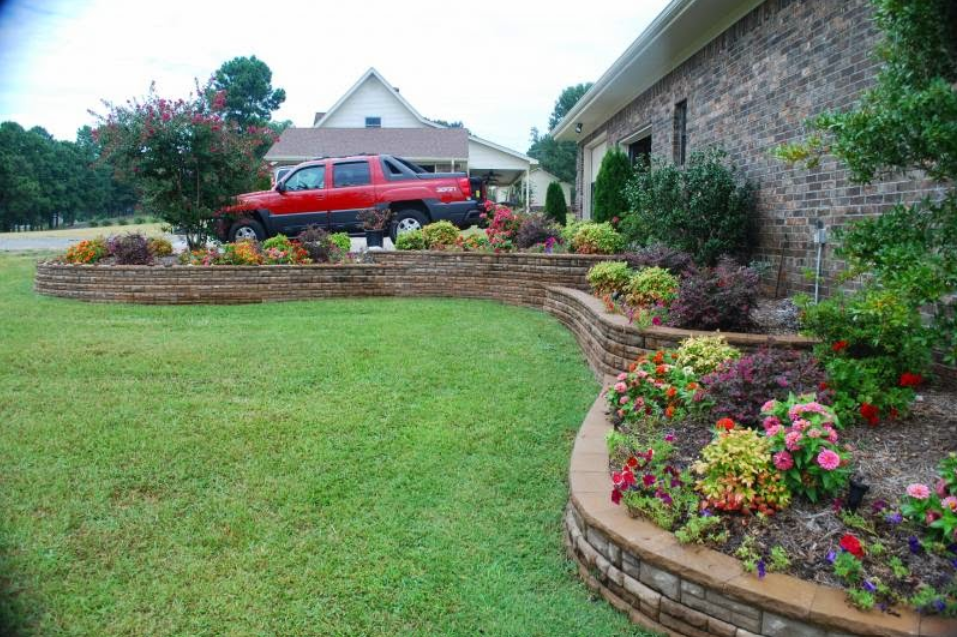 A red truck is parked in front of a brick house