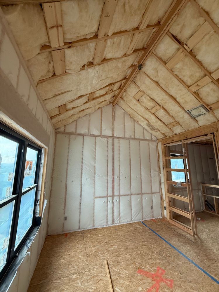 Insulated attic room with exposed rafters, unfinished walls, a window, and a ladder shelf.