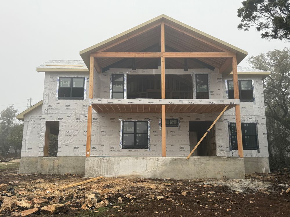 Partially built two-story house with exposed framing and unfinished exterior walls