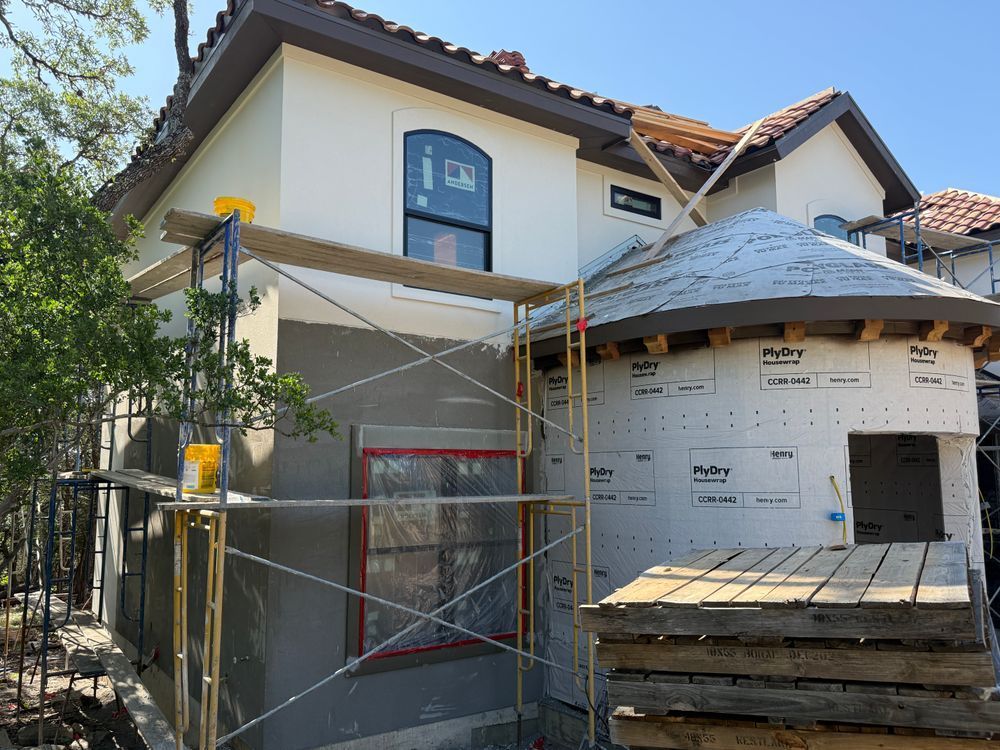House exterior under renovation with scaffolding and wrapped windows
