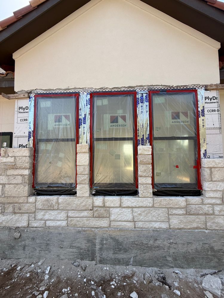 New house facade with three windows and stone foundation