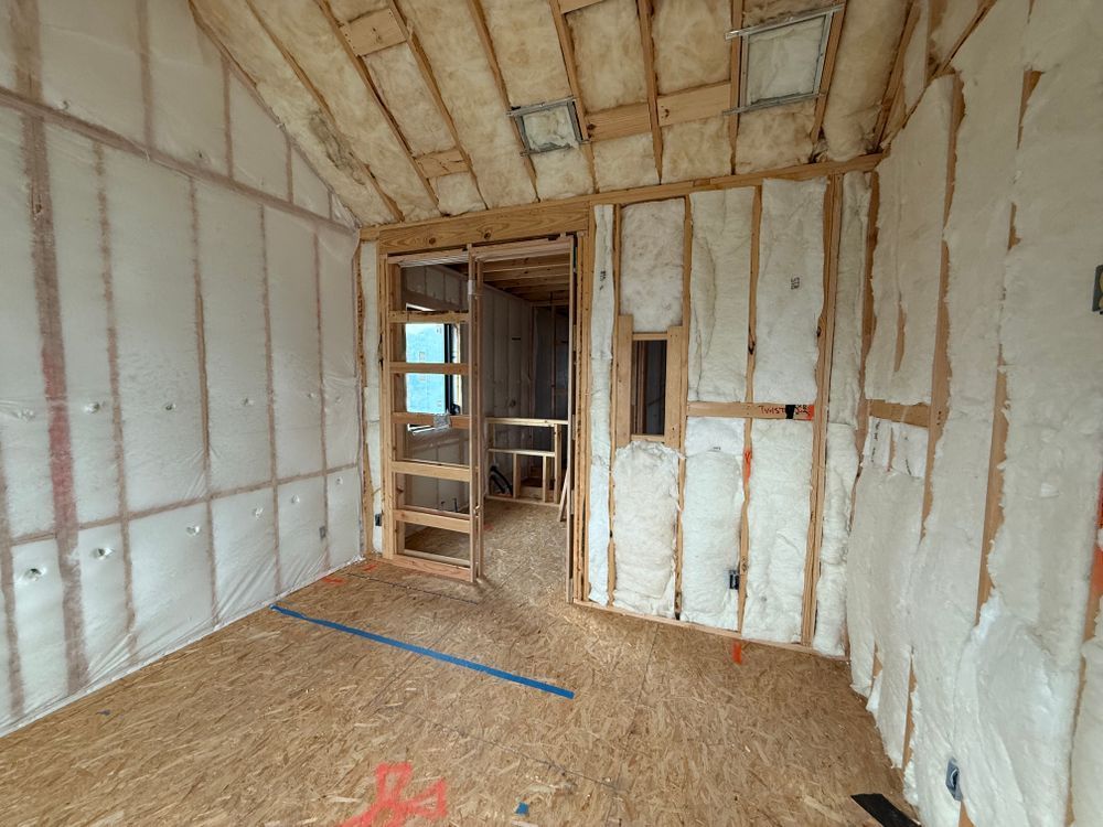 Unfinished room with insulated walls, exposed framing, and plywood subfloor under construction.