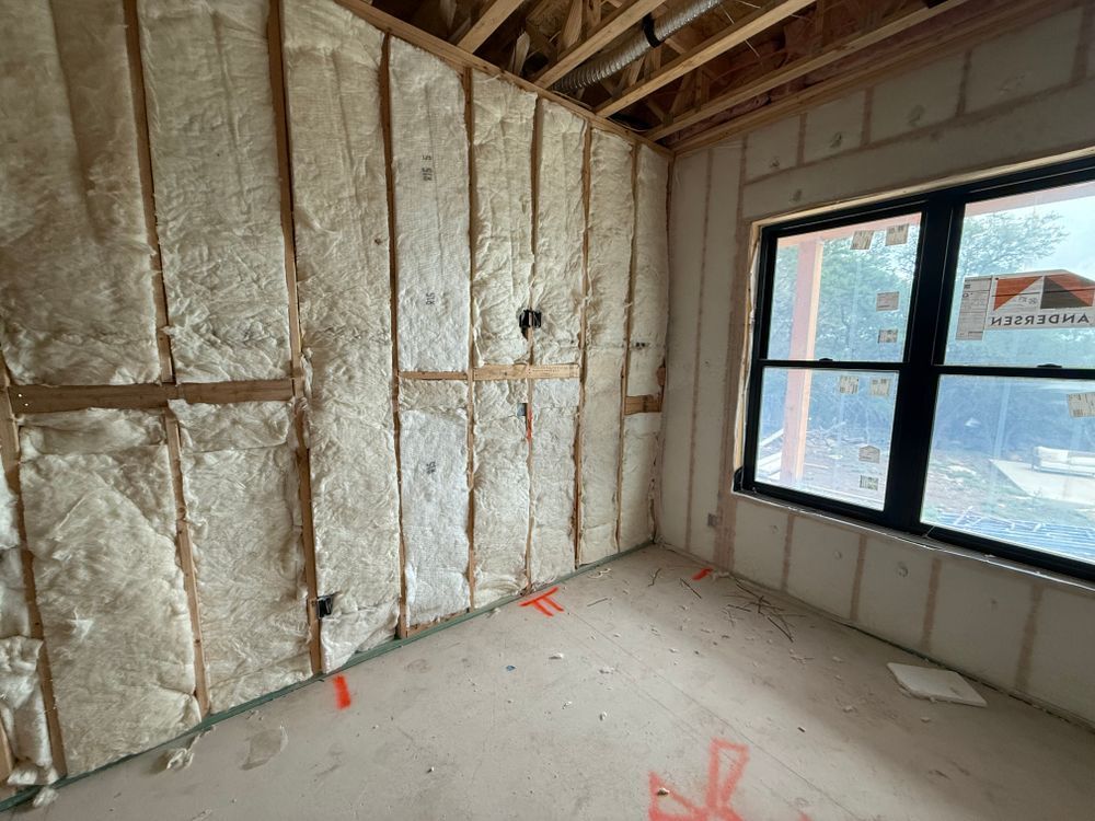 Unfinished room with insulated walls, exposed ceiling, concrete floor, and large window on the right.