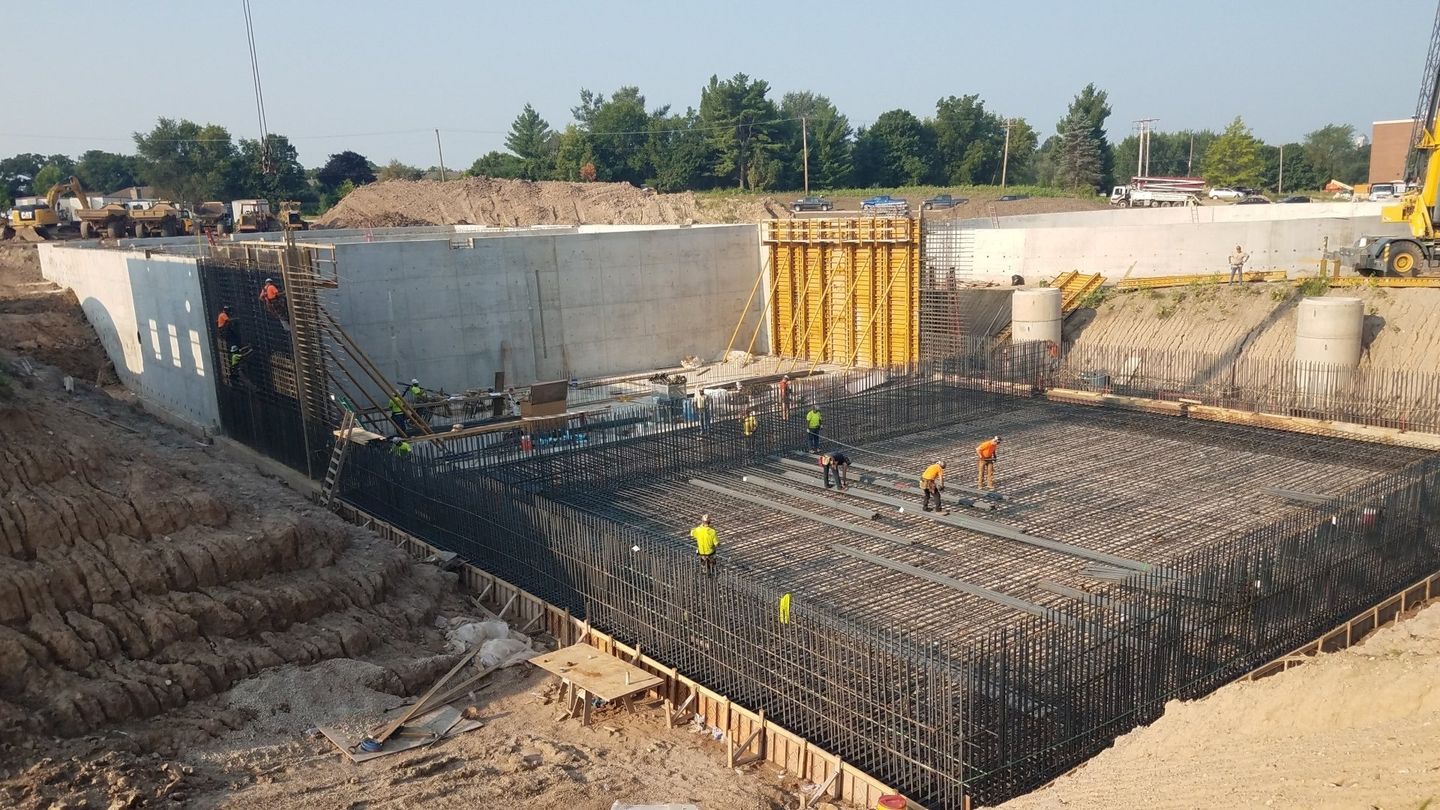 A large concrete structure is being built in the middle of a dirt field.