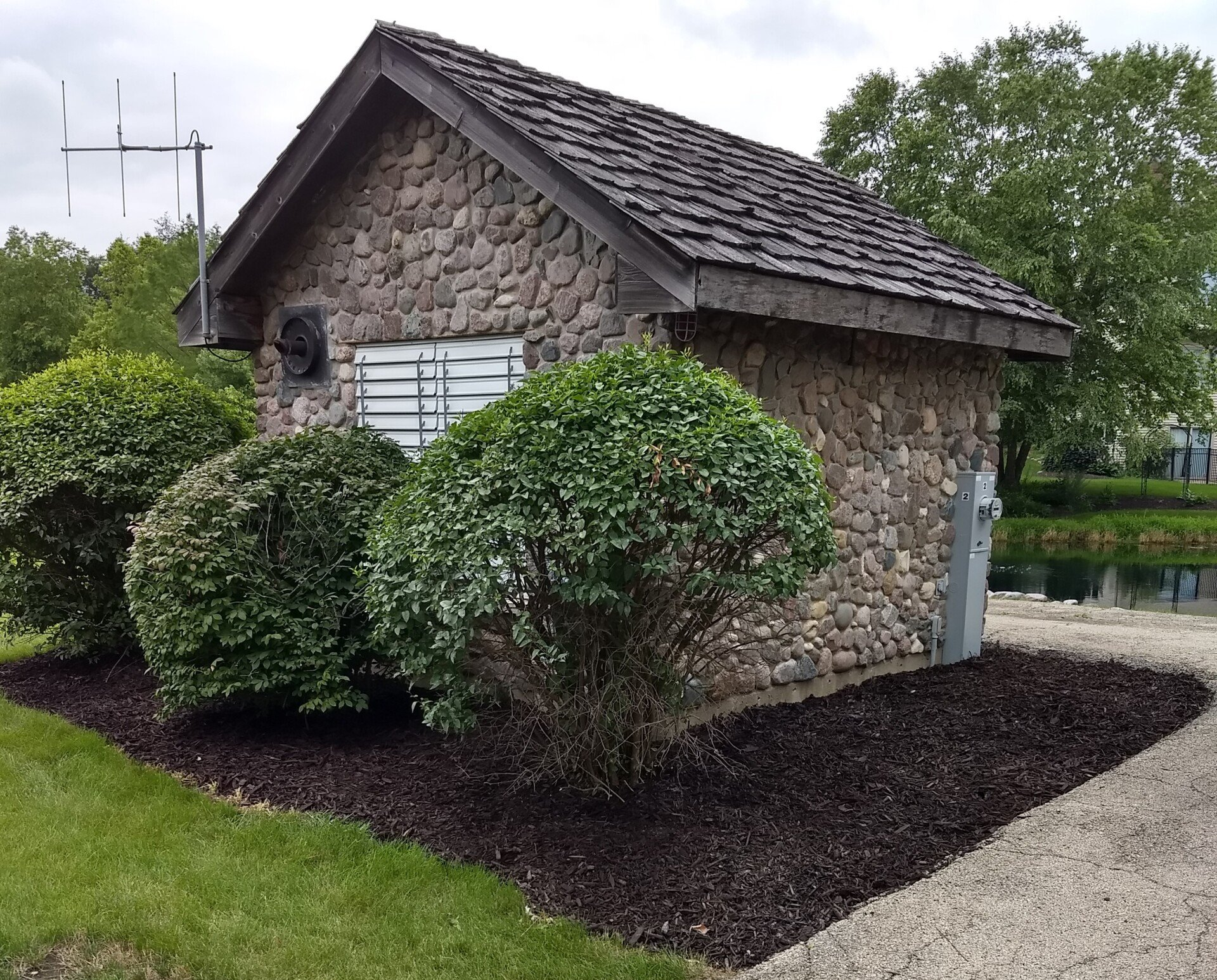 A small stone building with a shingle roof