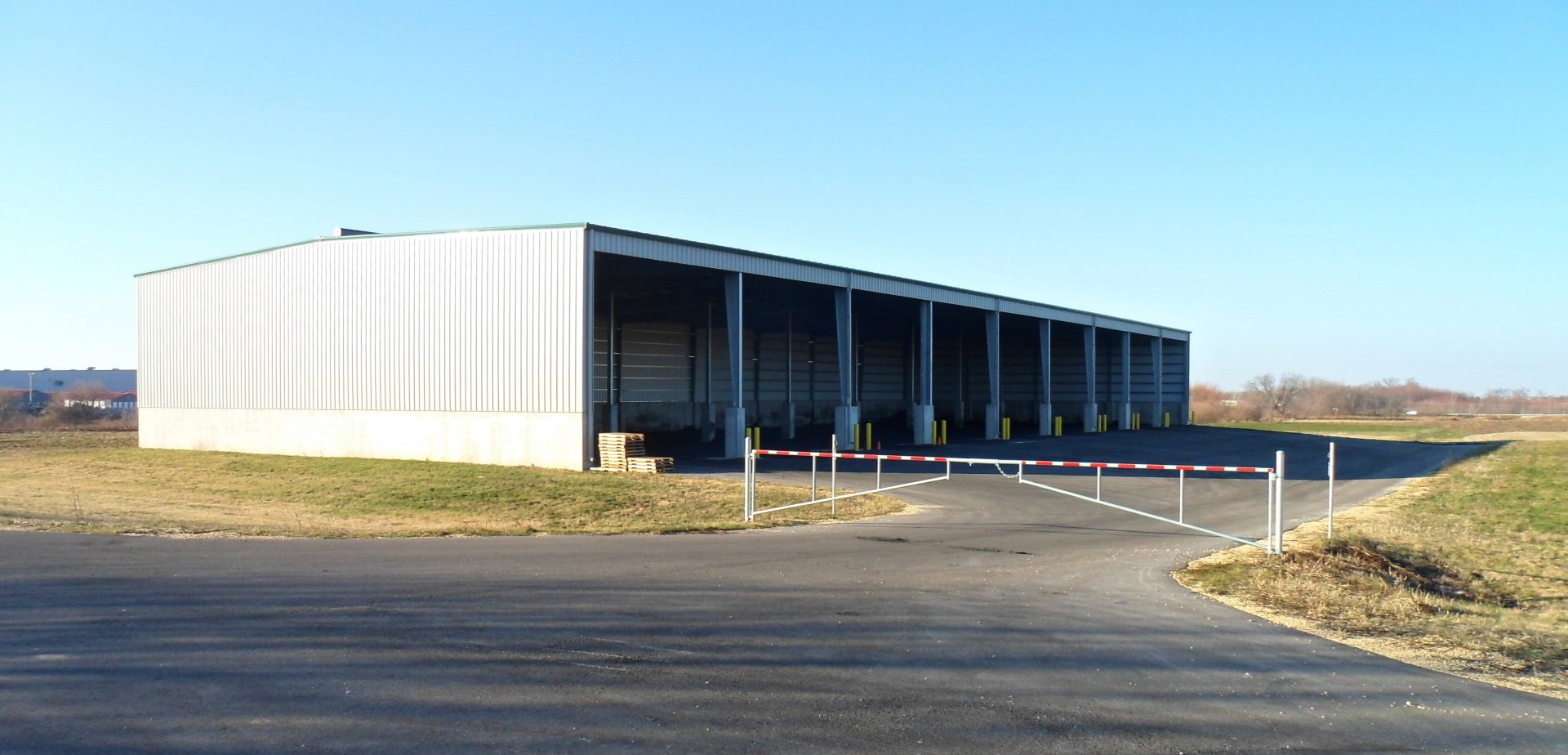 A large white building is sitting on the side of a road.