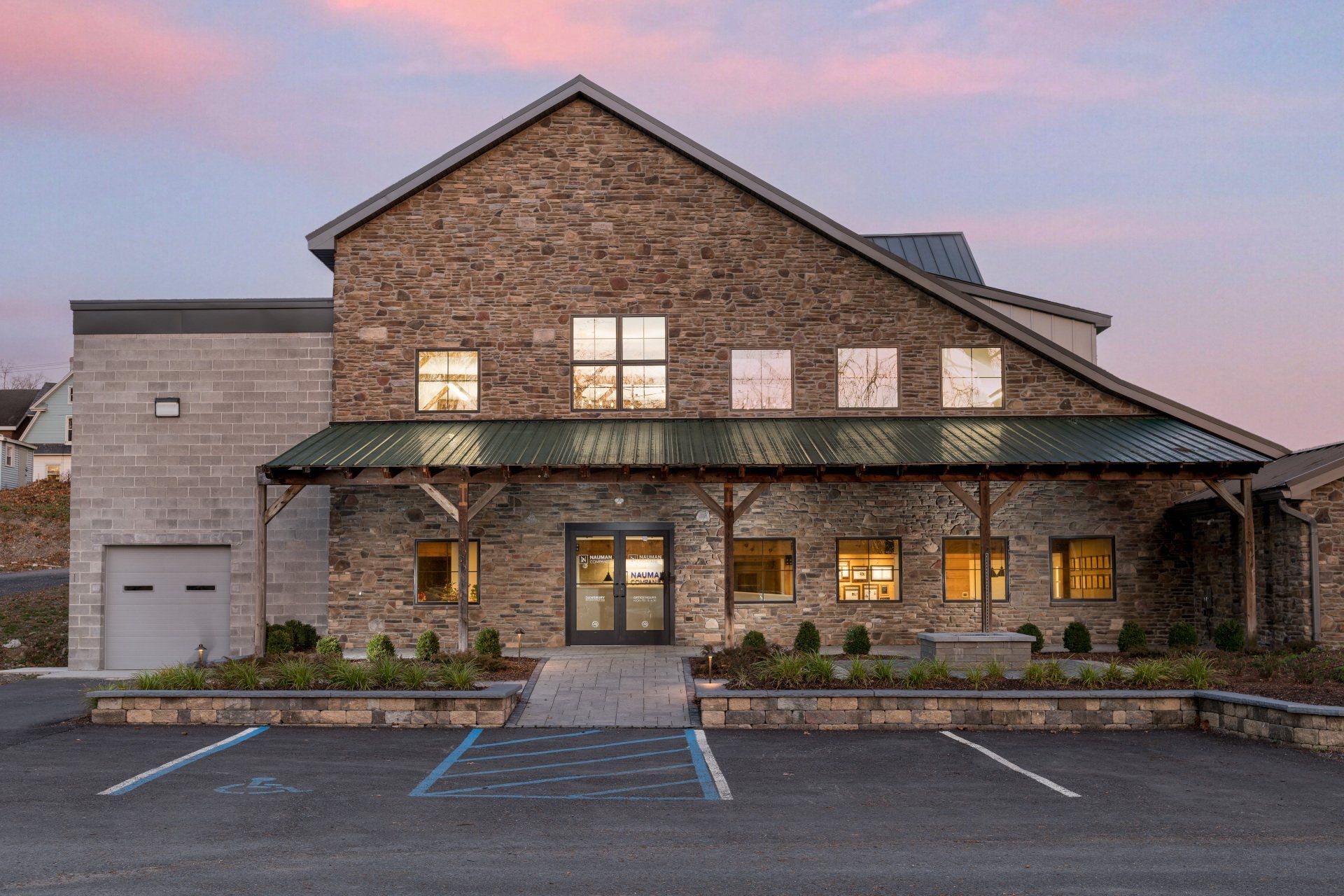 A large stone building with a parking lot in front of it.