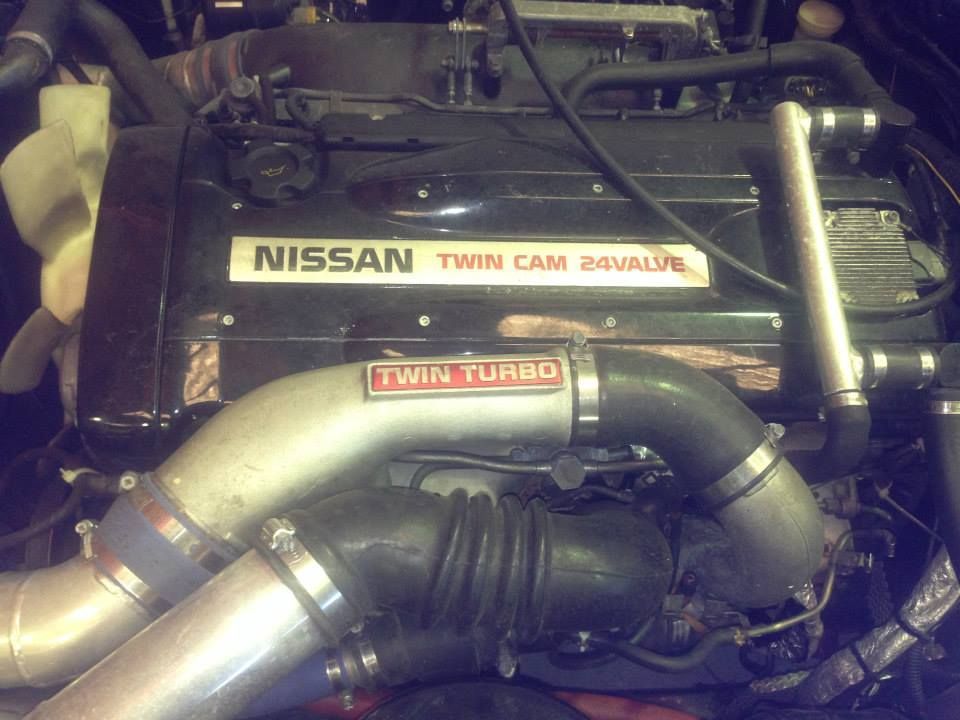 Close-up of a black Nissan engine with