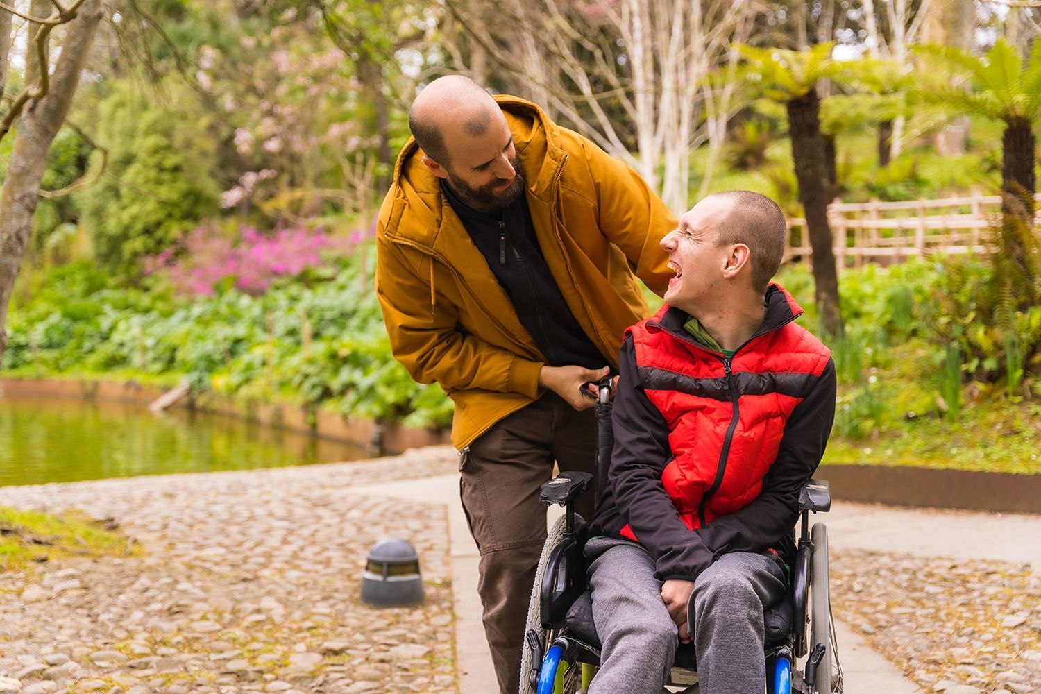 a man guiding another man on a wheelchair