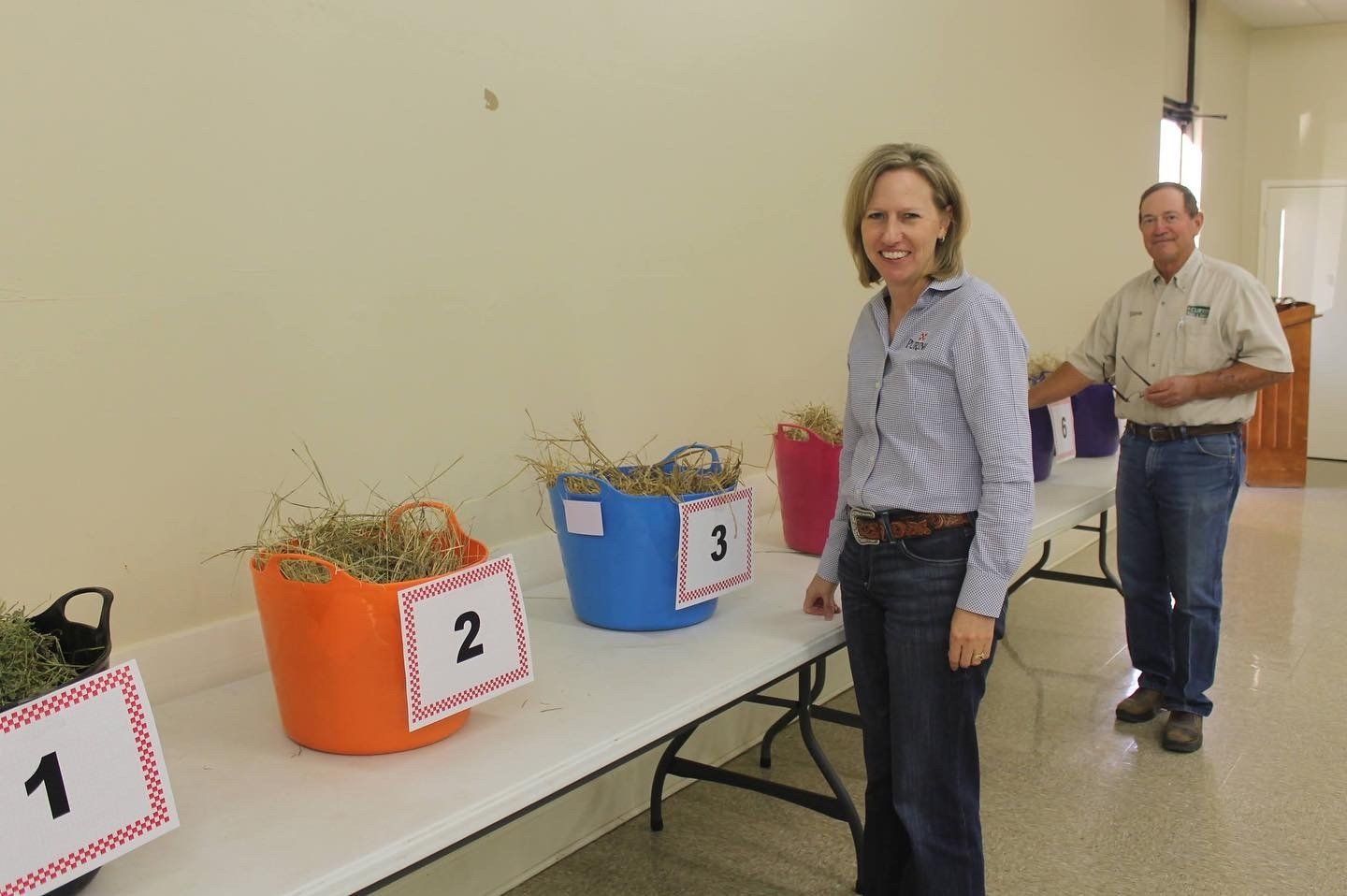A man and a woman are standing in front of a table with buckets on it.