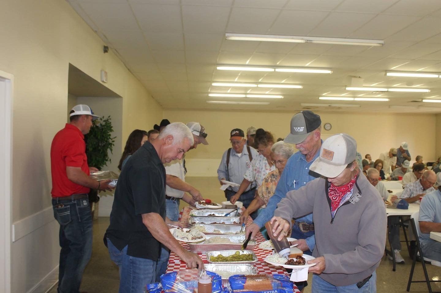 A group of people are standing around a table eating food