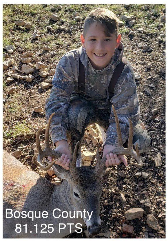 A young boy is holding a deer in his hands.