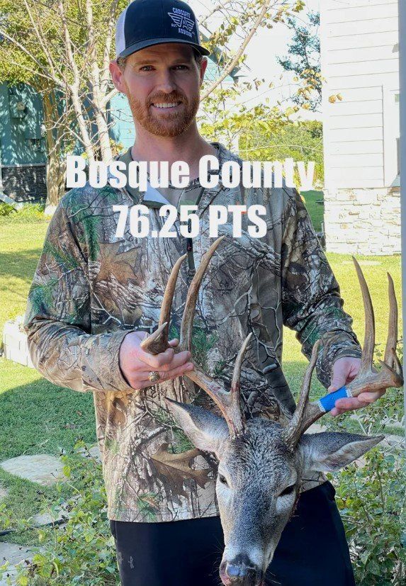 Man in camo with a buck he hunted; Bosque County, TX, 76.25 PTS. Outdoors, sunny, smiling.