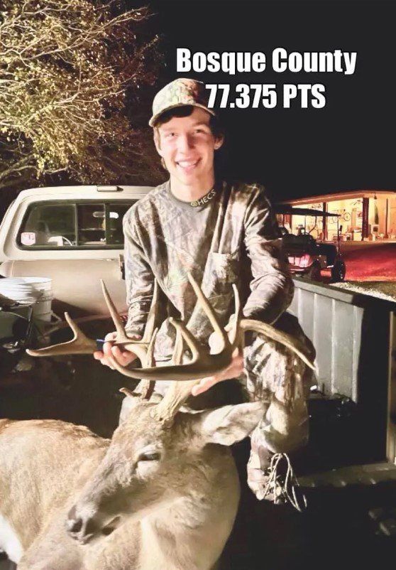 A young man in camo holding a buck with large antlers, Bosque County, 77.375 points.