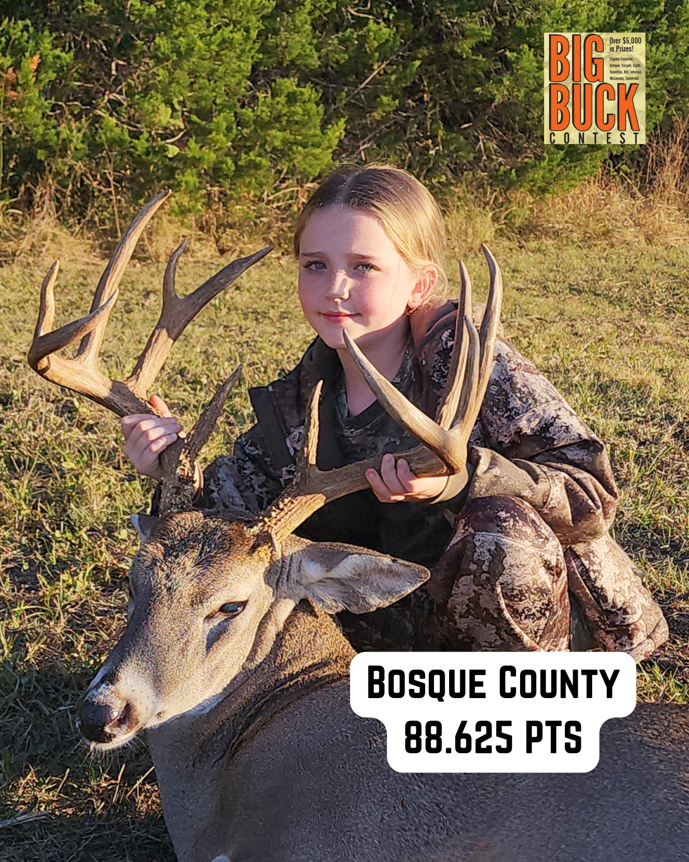 Young person in camouflage holds a large deer antler. 