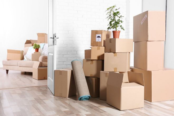 A living room filled with cardboard boxes and a couch.