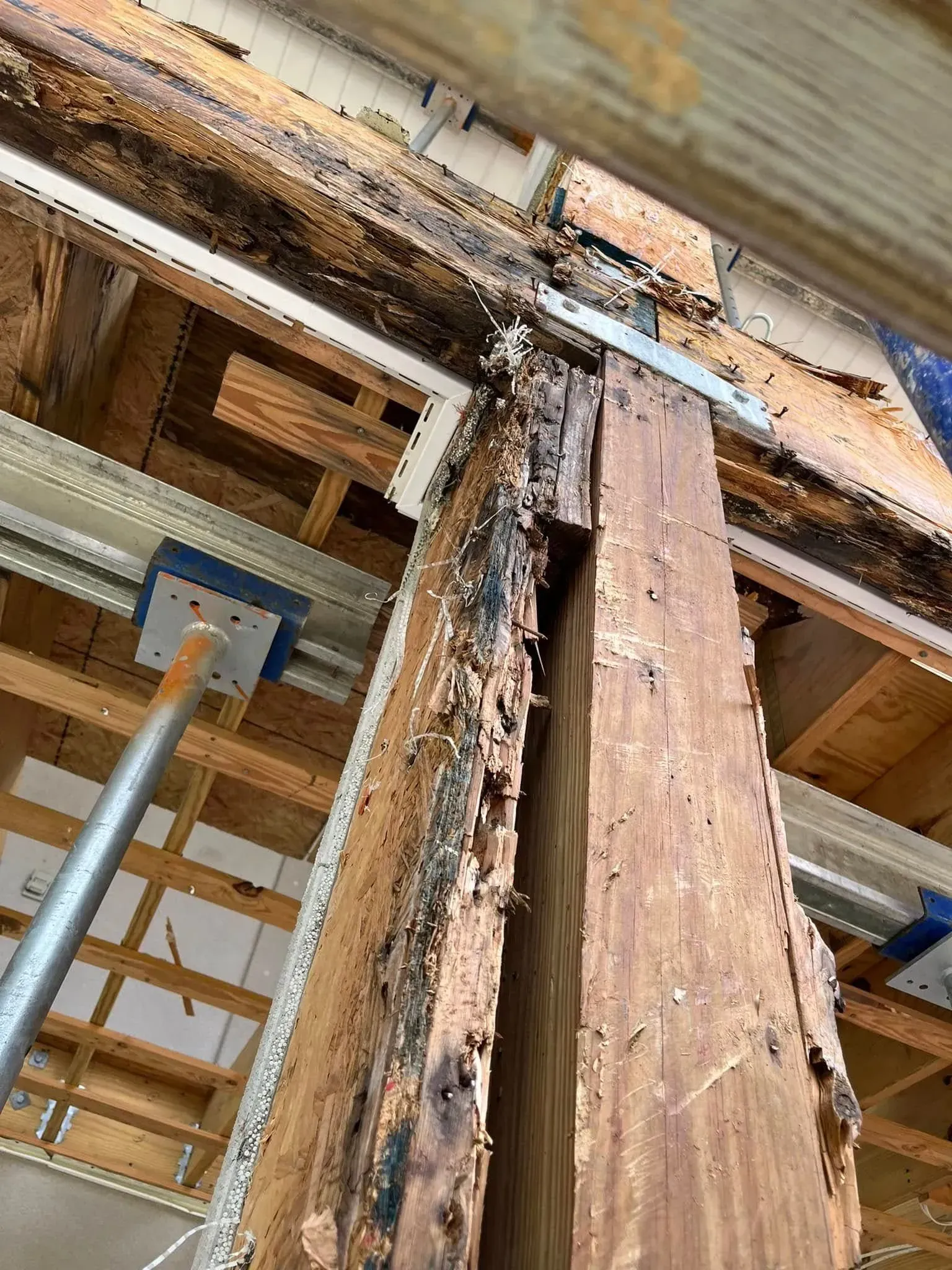 A wooden beam is being removed from the ceiling of a building.