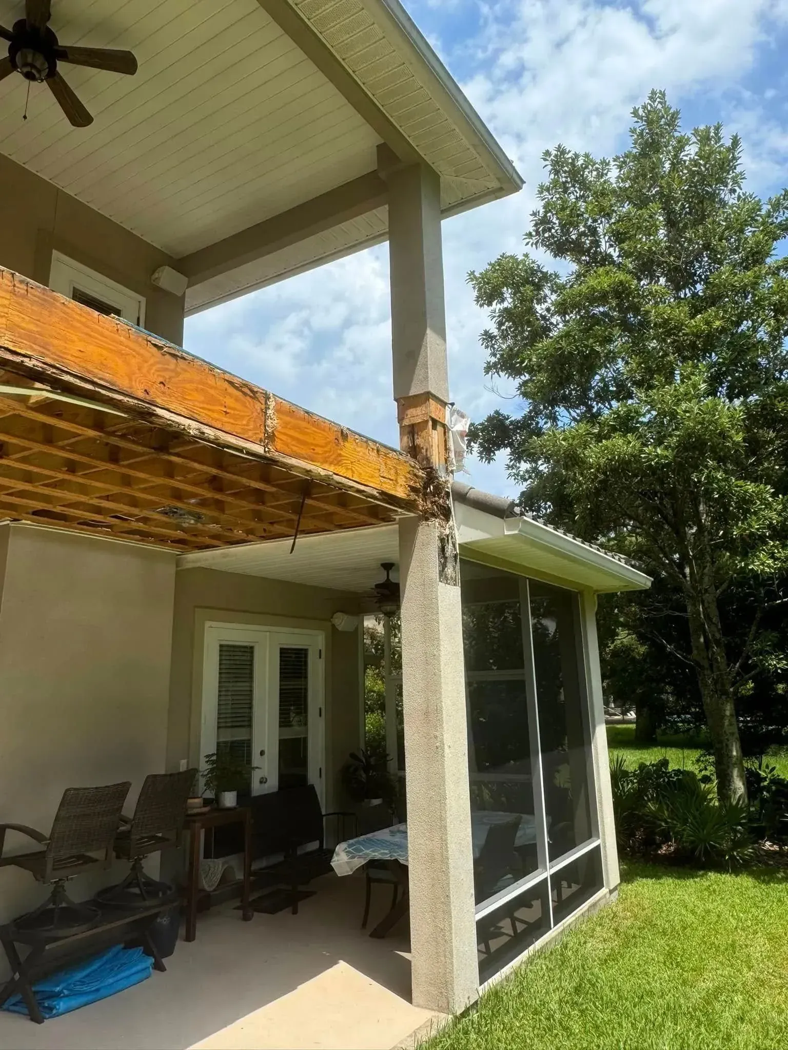 A house with a screened in porch and a ceiling fan.
