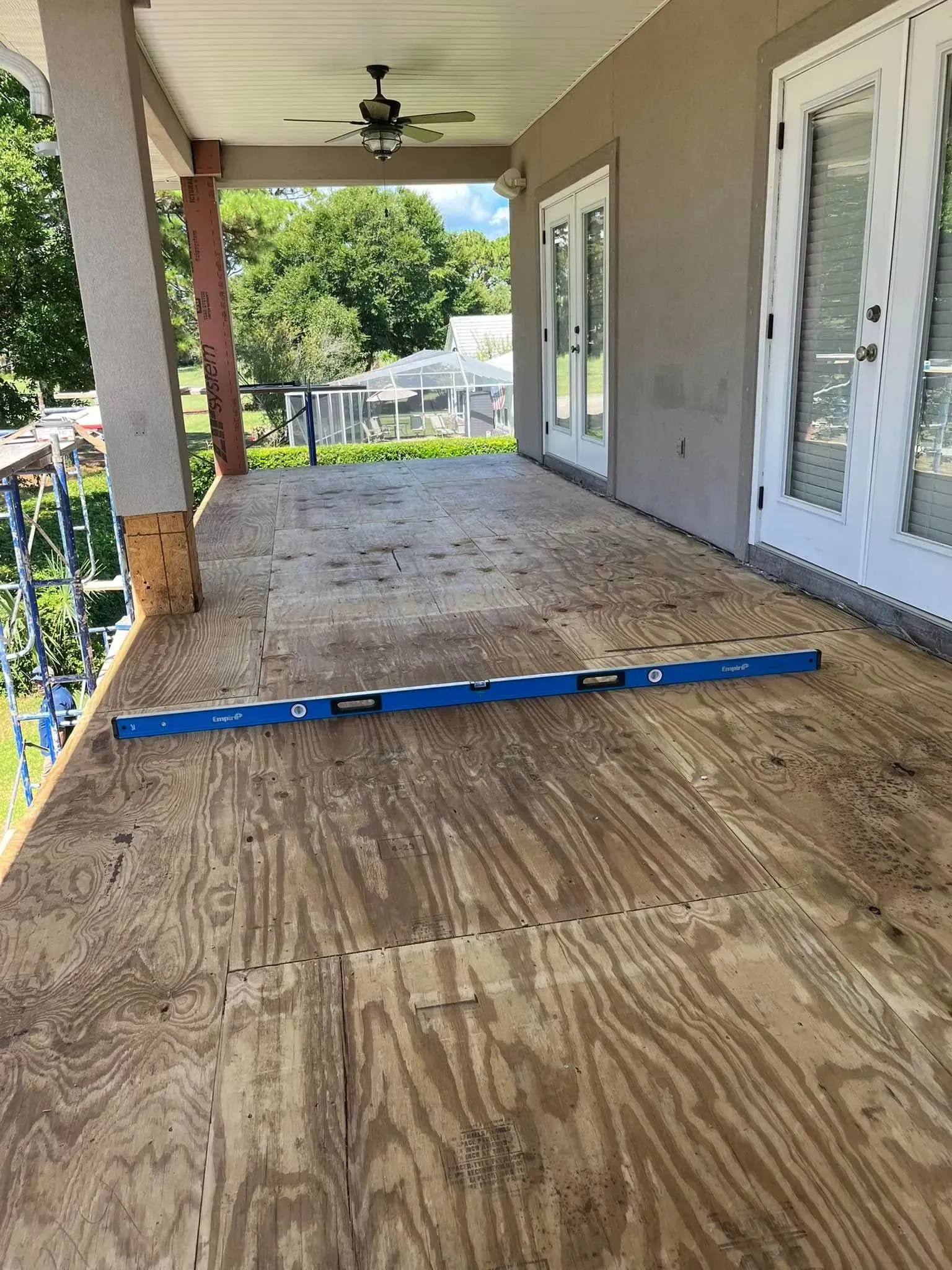 A blue level is sitting on top of a wooden porch.