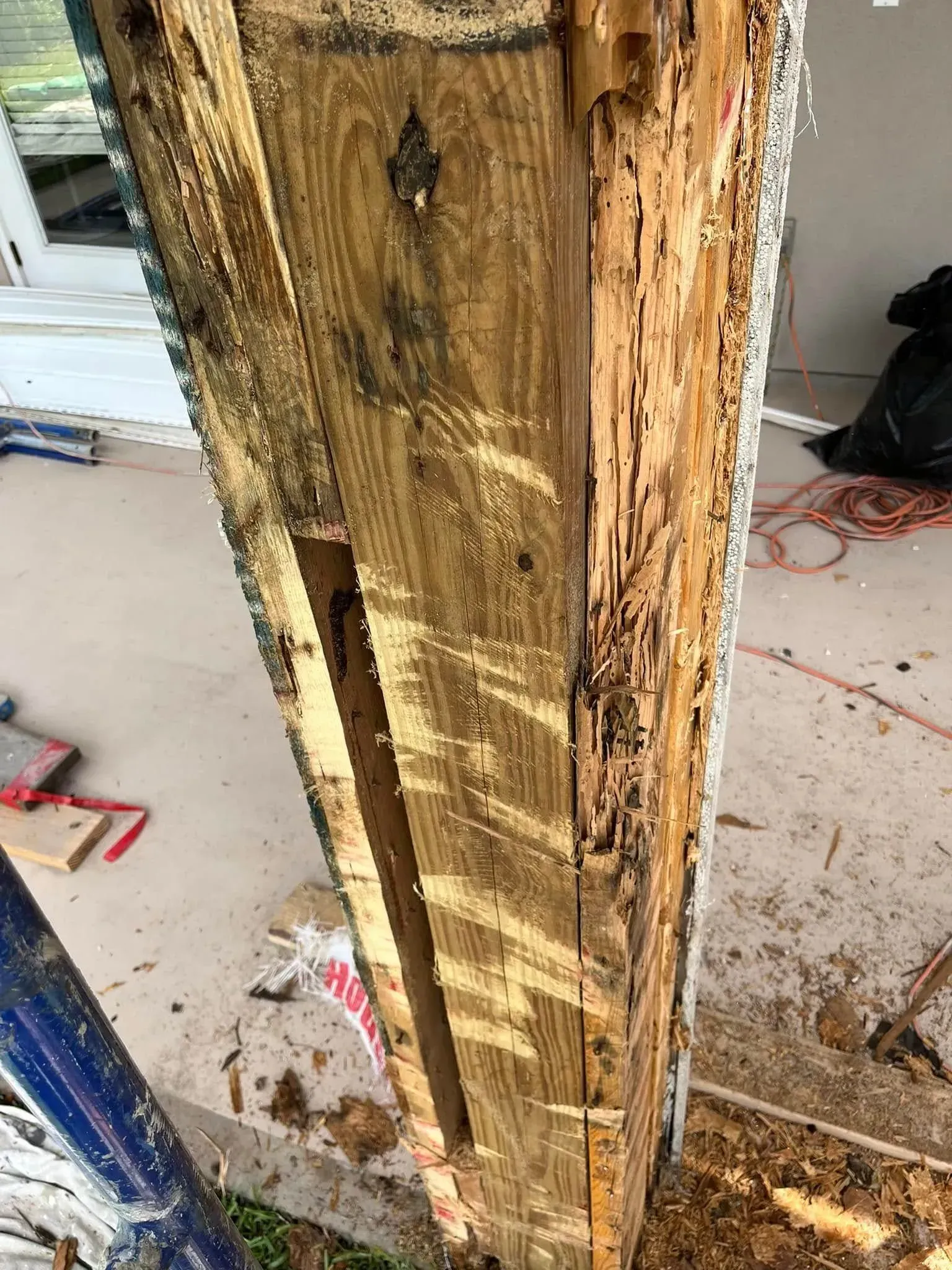 A close up of a wooden post that has been damaged by termites.