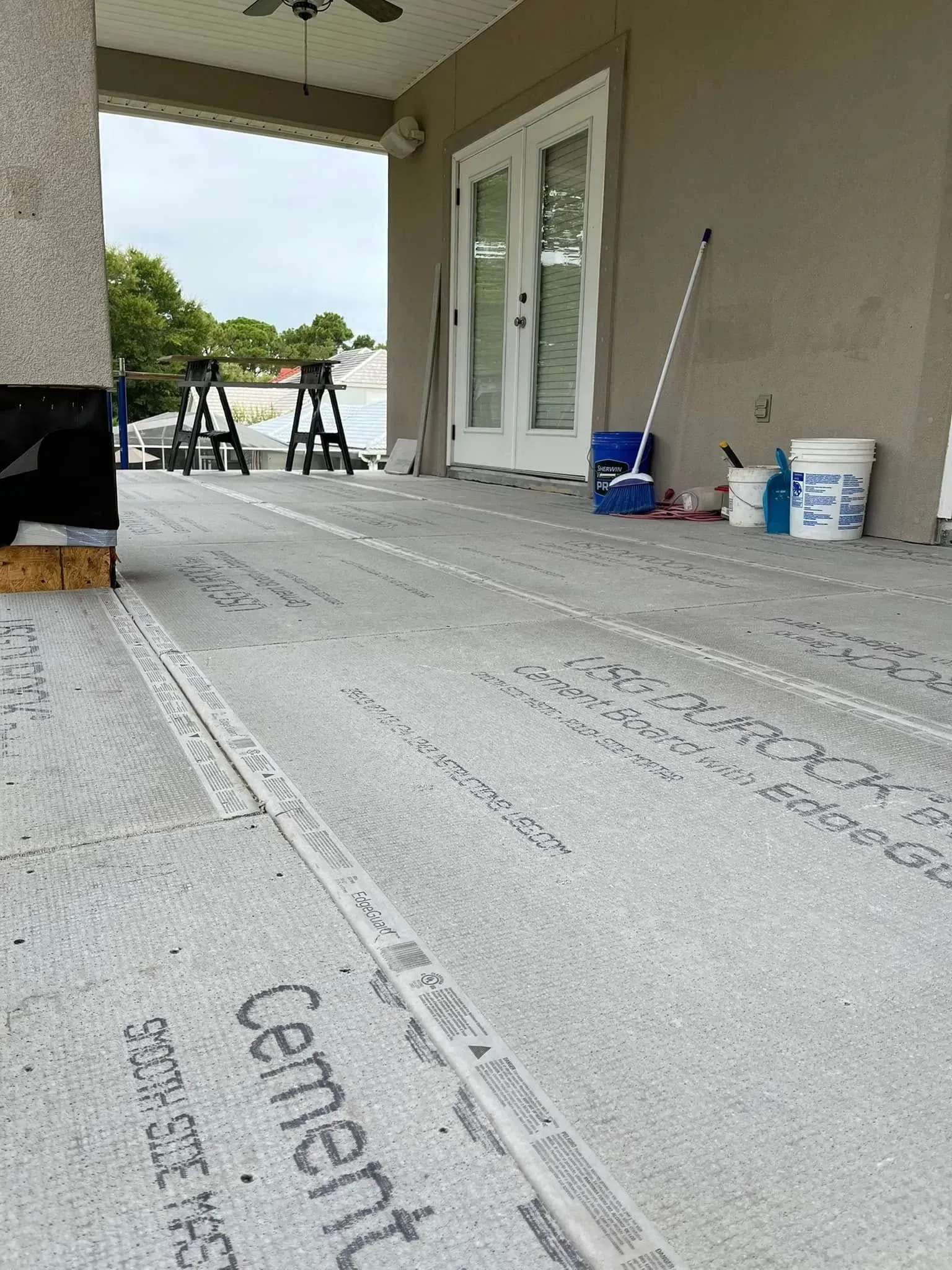 A patio is being built with a concrete floor and a ceiling fan.